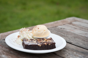 Brownie on white plate with ice cream