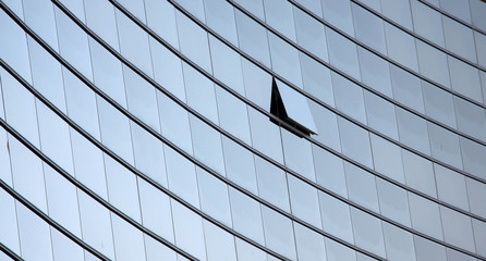 An open window in a row of similar dark office windows depicting a uniqueness concept