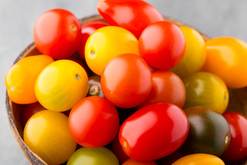 Tomatoes on the gray background. Colorful tomatoes, red tomatoes