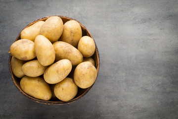 New potato on the bowl, gray background.