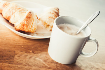 Cappuccino and croissant. Retro cup of coffee