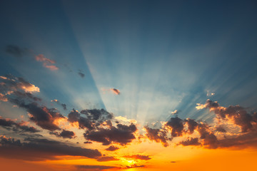 Sunset dramatic sky clouds with sunbeam