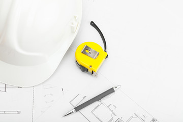 Construction helmet with pencil and measure tape near it
