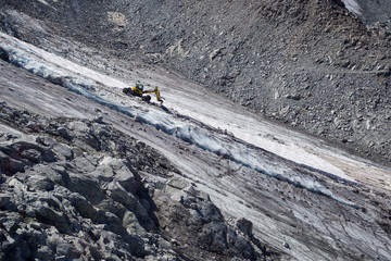 Mechanical shovel digs in Presena's glacier, Italy