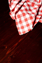 Obraz premium top view of checkered napkin on wooden table