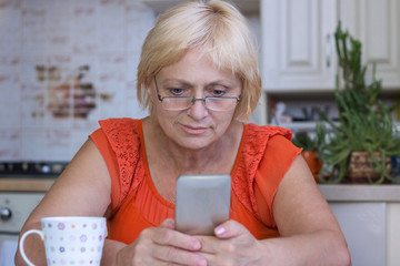 Elderly woman sends sms on cellar phone
