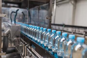 Water factory - Water bottling line for processing and bottling pure spring water into small blue plastic bottles.