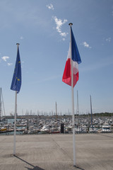Fototapeta premium French and European flag with port in background