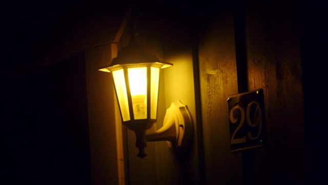 Zoom in on a yellow glowing lantern outside a house number 29