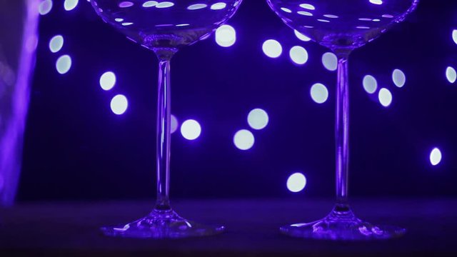two empty wine glasses on the table in the blue light