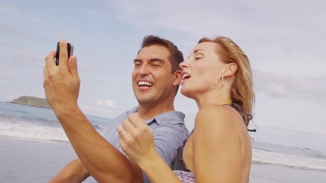 Couple taking photo together at beach, Costa Rica
