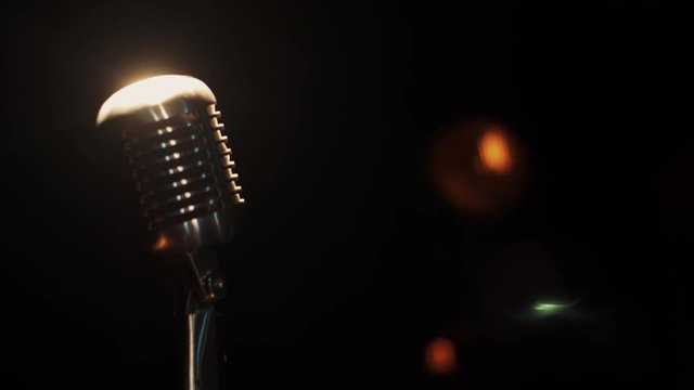 View of concert vintage microphone stay on stage in closed club under spotlight. Zoom in