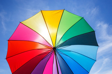 open colorful rainbow umbrella on blue sky background