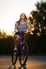 Fototapeta premium girl on a bicycle at sunset