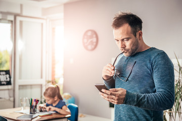 Worried father looking at smart phone