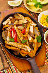Chicken Fajitas with Grilled Onions and Bell Peppers serve with Tortillas. Selective focus.