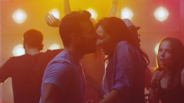 People Dancing, Having Fun and Raising Hands in Nightclub. Young Man and Woman dancing Together. Shot on RED Cinema Camera in 4K (UHD).