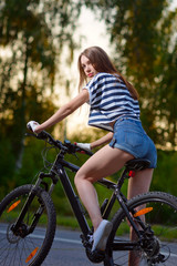 Plakat girl on a bicycle at sunset