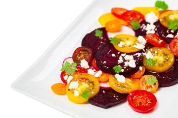Tomato Beet Salad with Feta Isolated on white. Selective focus.