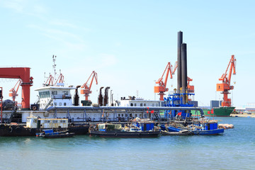 Fototapeta premium In freight terminal, gantry crane and cargo ships are in loading