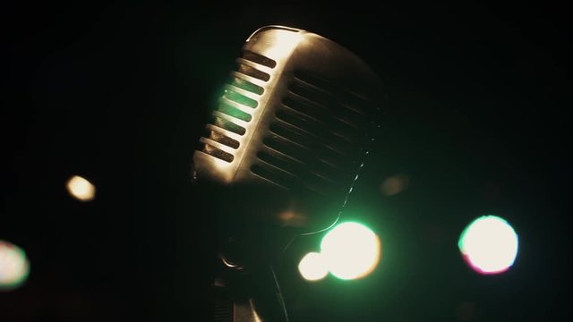 Concert vintage gleam microphone stand on stage in retro club. Green spotlights. Close up.