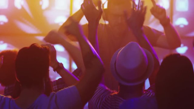 DJ Playing Music in Nightclub, People Dancing, Having Fun and Raising Hands. Shot on RED Cinema Camera in 4K (UHD).
