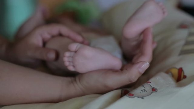Baby's legs in mother hands
