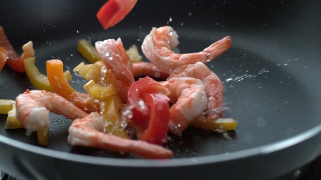 Stir fry splashing into hot oil in frying pan, slow motion; shot on Phantom Flex 4K at 1000 fps