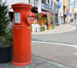 Fototapeta na wymiar 日本の懐かしい丸型郵便ポストのある街角