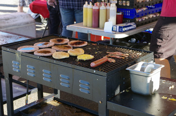 Cook pours melted cheese over hot dogs at the outdoor festival