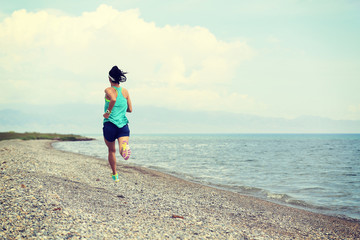 healthy young fitness woman trail runner running on seaside