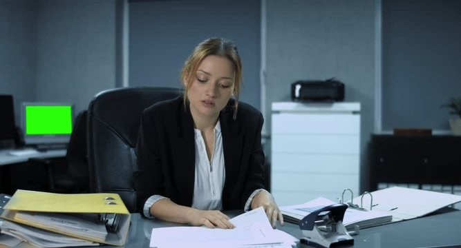 4K: Eine junge, leicht &uuml;berm&uuml;dete B&uuml;roangestellte heftet die letzten Dokumente ab und freut sich auf das Wochenende. Die Vorgesetzte legt ihr jedoch noch einige Akten auf den Tisch.