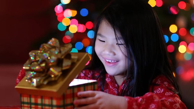 Young girl opens opens Christmas present