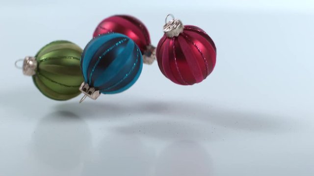 Christmas ornaments falling and bouncing in slow motion