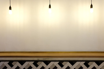 Lamps hanging down on white wall with wooden decoration