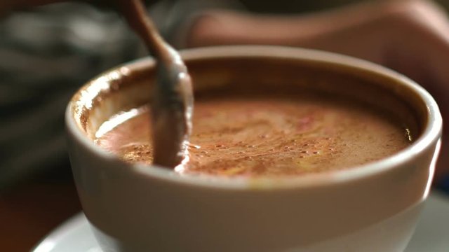 Teaspoon stir crema. Unknown going to drink latte in the white mug
