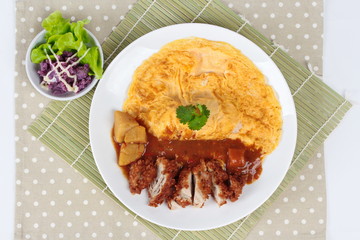 Omelet rice with deep fried chicken in Japanese yellow curry  with butter mashed potatoes salad  on bamboo gray. Top view.