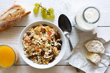 Healthy breakfast with muesli, grapes, cheese and juice on rustic table.