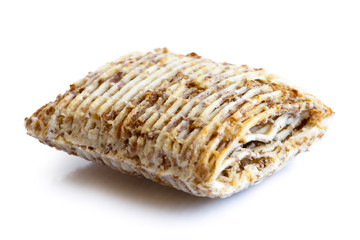 Single mini shredded wholegrain biscuit isolated on white.