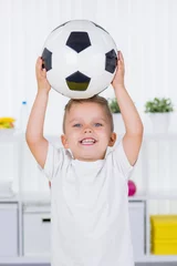 Poster kind hält begeistert einen ball hoch © Racle Fotodesign