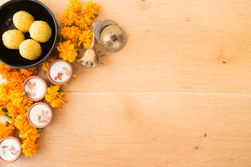 Diwali prayer celebration preparation  with sweets, marigold flowers, diyas and music instruments and copy space background 