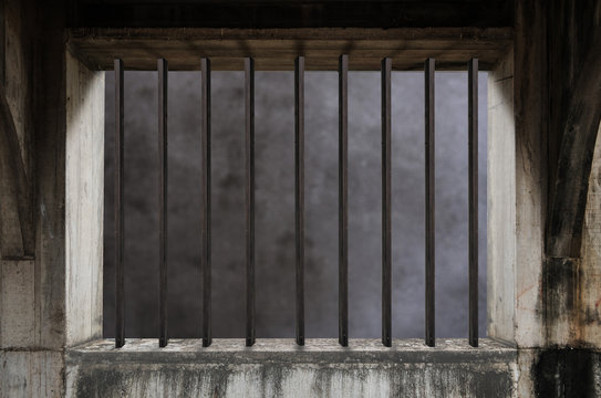 Interior of a prison cell with light shining through a barred window