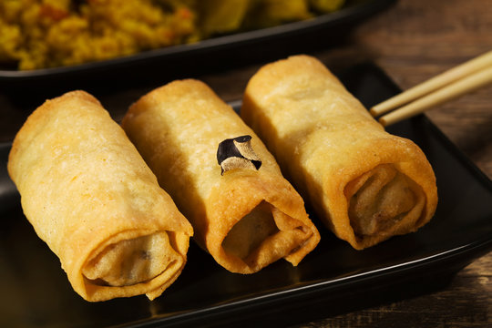 Baked spring rolls with vegetables on a black plate