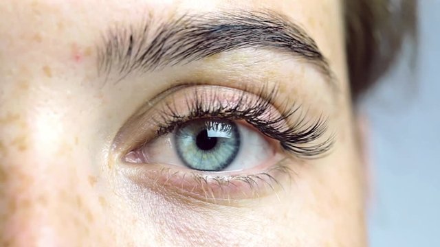 Eye of the girl close-up, woman opening her blue eye