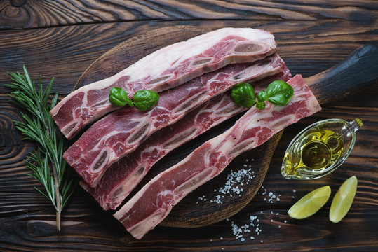 Raw seasoned beef short ribs in a rustic wooden setting