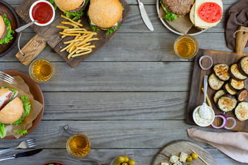 Frame from different burgers and snacks on wooden table © kucherav