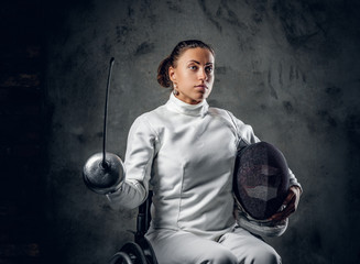 Female fencer in wheelchair with safety mask and rapier.