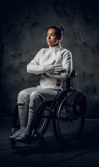 Female fencer in wheelchair with safety mask and rapier.