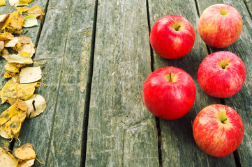 Wooden background with autumn apple and leaves