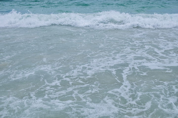 Fototapeta na wymiar Close-up wave of blue sea on the beach
